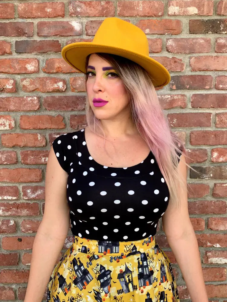 Yellow felt fedora hat paired with vintage polka dot boat neck cap sleeve top for stylish casual wear