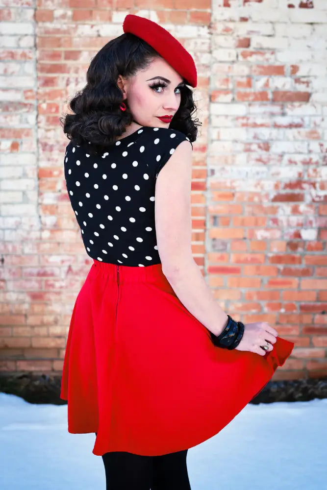 Red beret with a smooth structured crown and soft brim paired with a vintage polka dot boat neck cap sleeve top