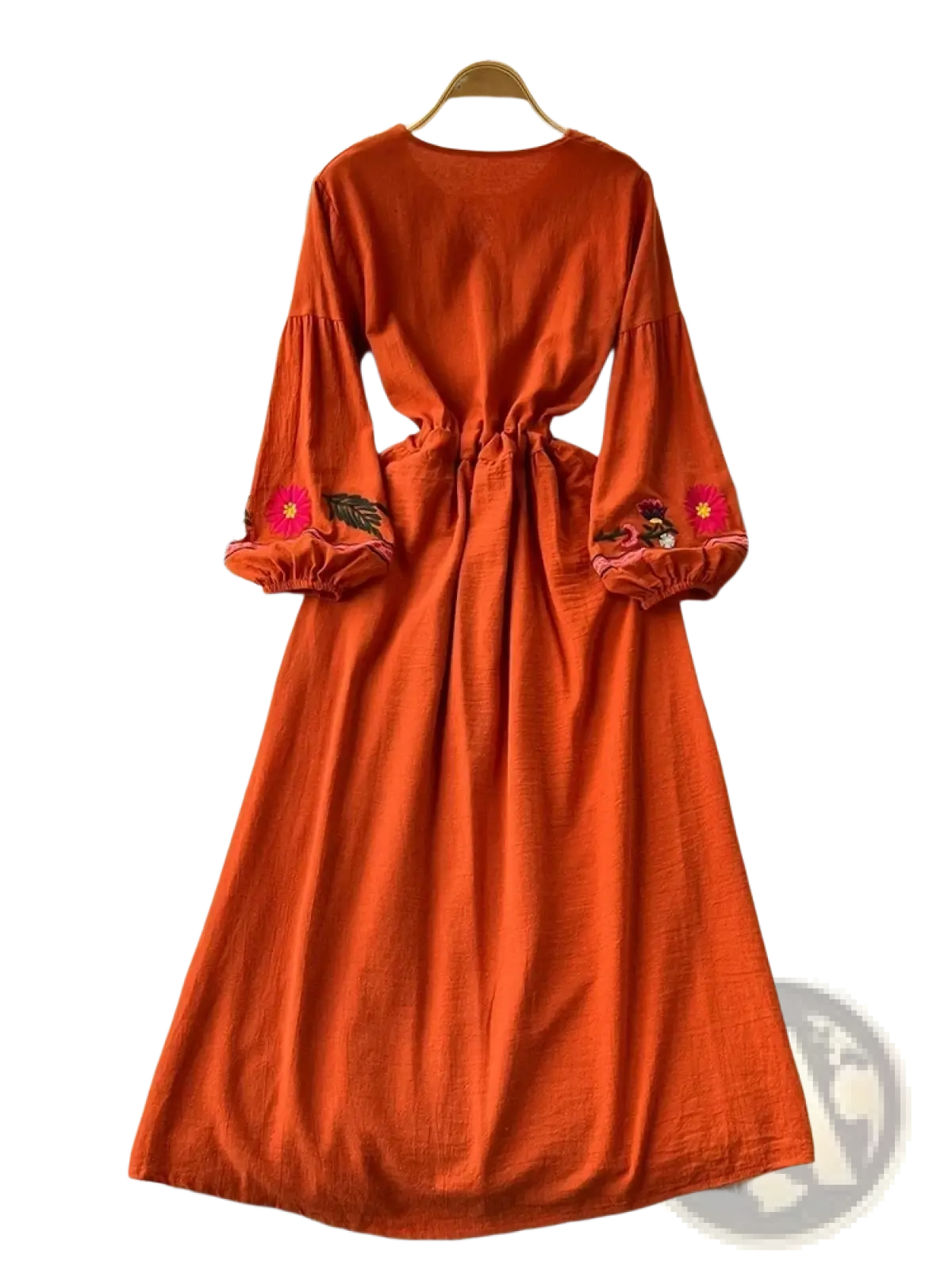 A vibrant orange bohemian long sleeve dress with floral embroidery on cuffs displayed on a hanger