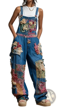 Blue denim overalls featuring colorful embroidered floral patches and decorative fabric appliqués in a bohemian style