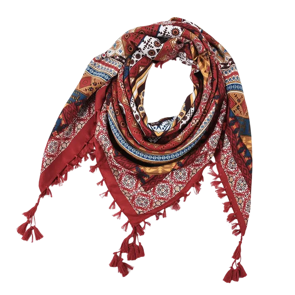 A richly patterned red bohemian floral square scarf with gold blue and white designs and decorative tassels on edges