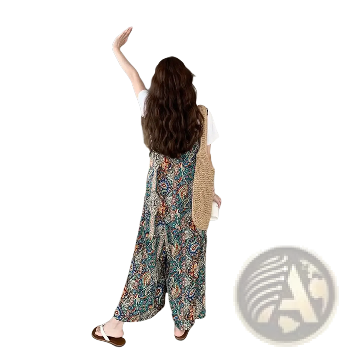 Woman wearing a colorful paisley patterned bohemian floral wide leg jumpsuit with a beige knitted vest over it