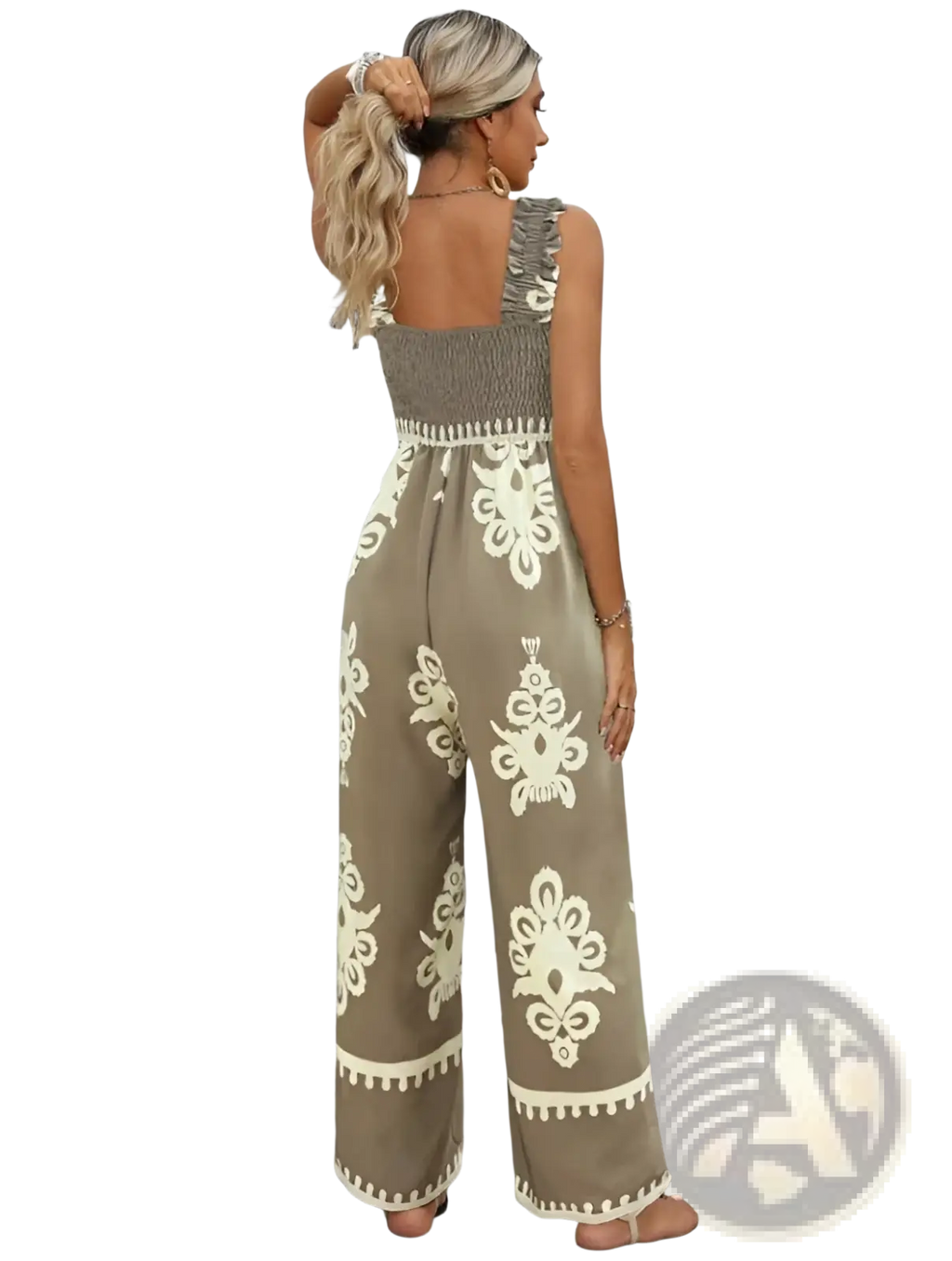 A woman wears a beige and cream bohemian printed wide leg jumpsuit with intricate floral embroidery along the hemline