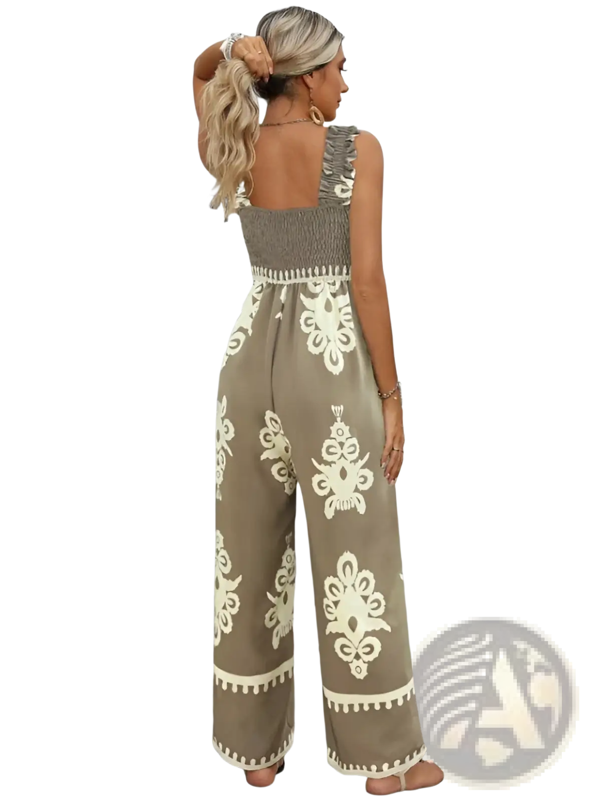 A woman wears a beige and cream bohemian printed wide leg jumpsuit with intricate floral embroidery along the hemline