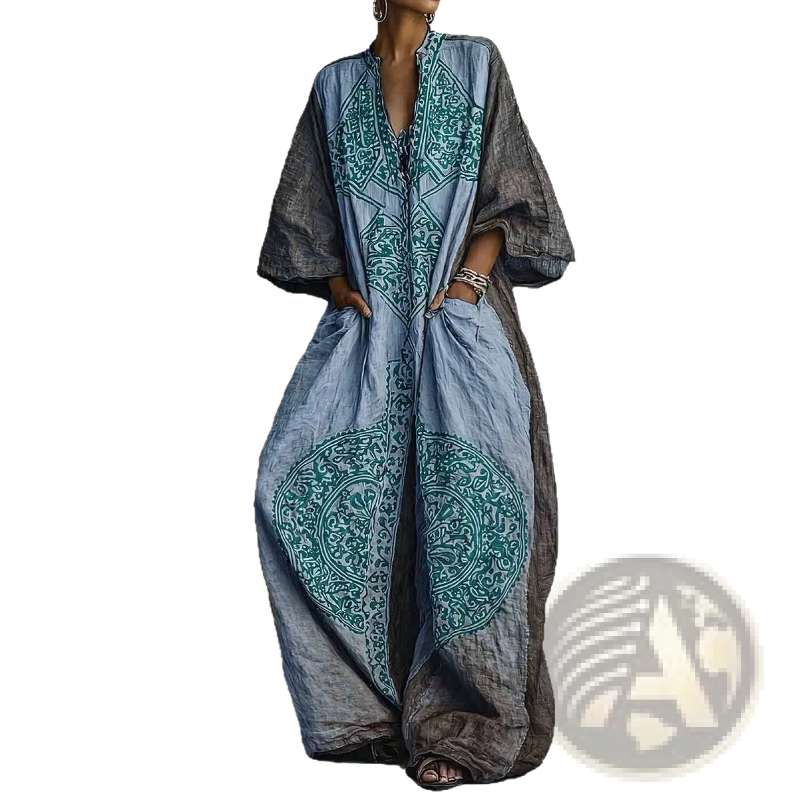 A flowing long-sleeved bohemian dress in faded blue denim with teal embroidery and contrasting dark gray sleeves