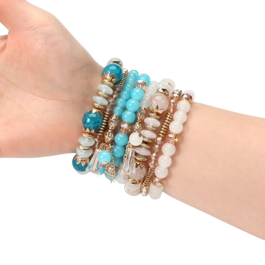 A stack of high quality bohemian stretch bracelets with turquoise white rose quartz and gold toned accents