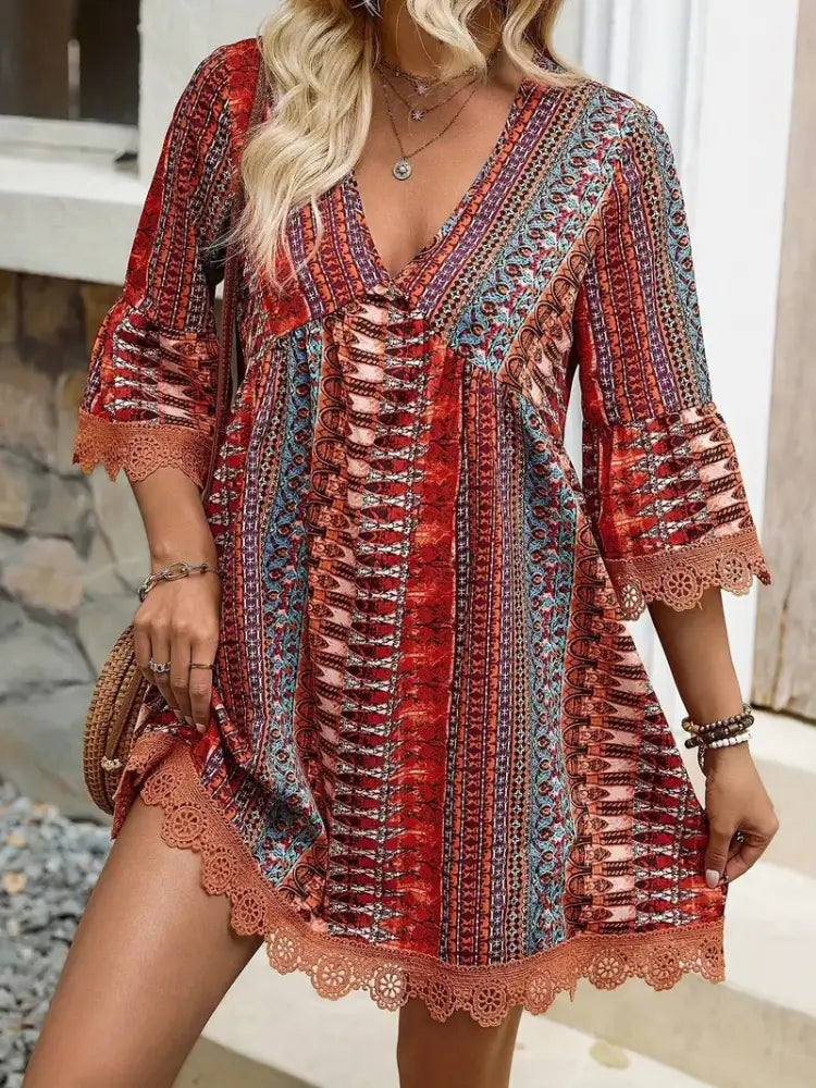 A vibrant red blue and beige embroidered bohemian v neck lace trim beach dress with lace cuffs and hem