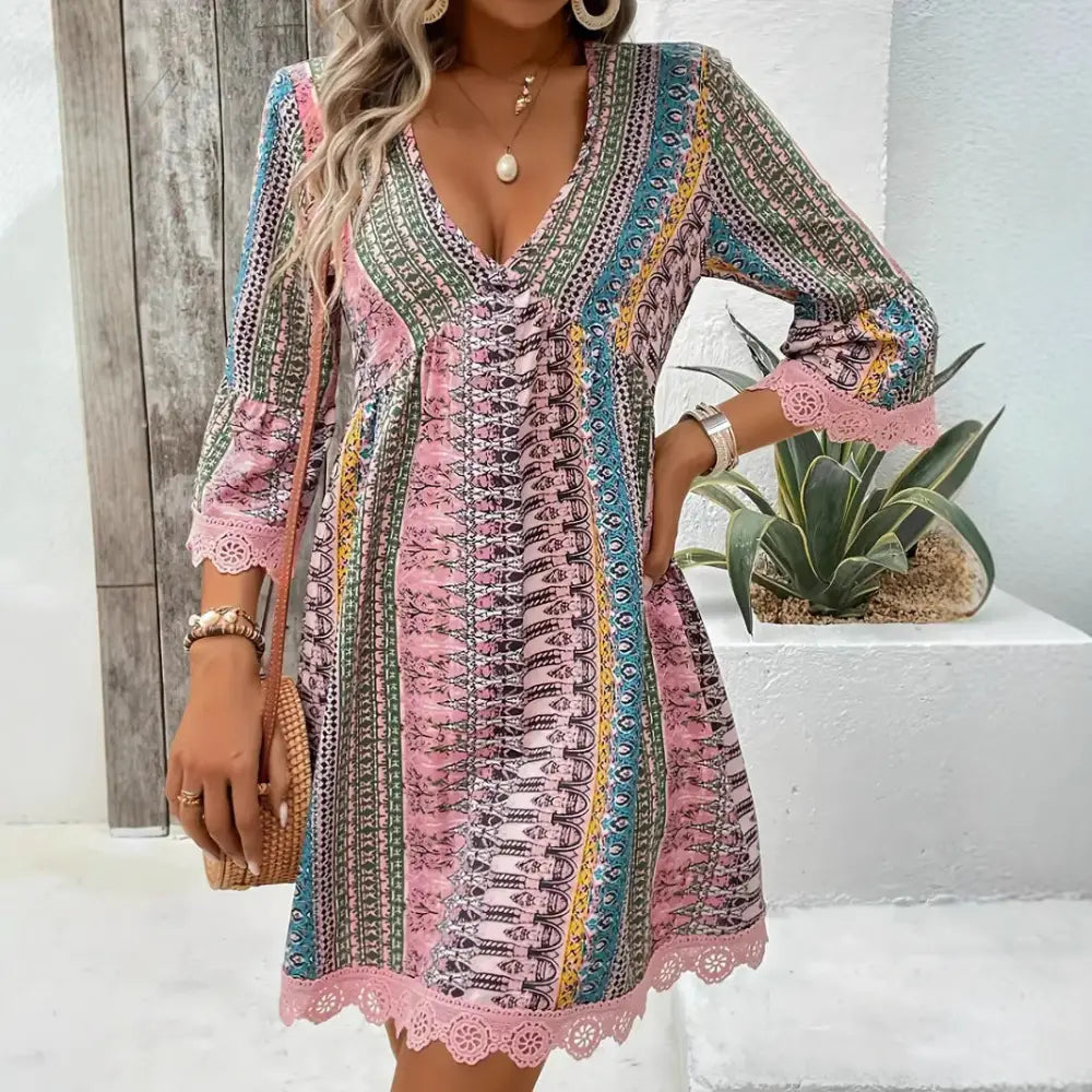 A vibrant long-sleeved embroidered bohemian v-neck beach dress with colorful geometric print and lace trim accents