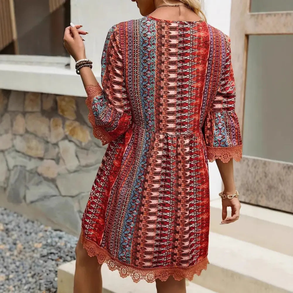 A vibrant red and blue embroidered bohemian v-neck lace trim beach dress with intricate geometric patterns and lace details