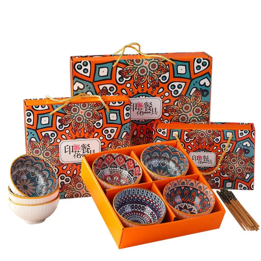 Set of four colorful ceramic bowls with intricate red blue and black mandala patterns in an orange gift box
