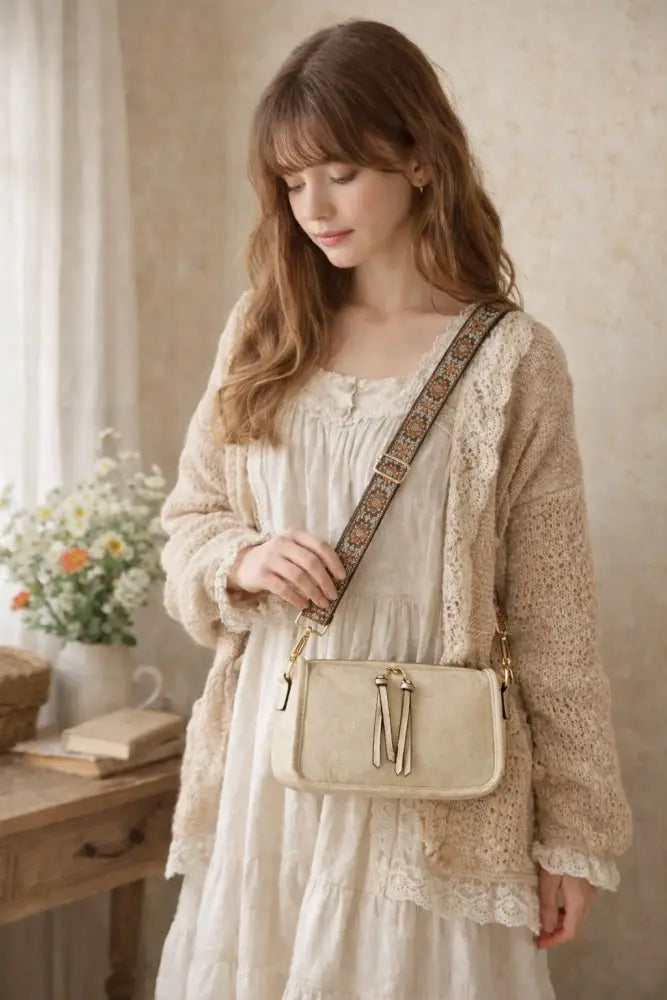 Beige aztec embroidered bohemian crossbody bag with decorative lace-trimmed strap and gold-tone tassel closure