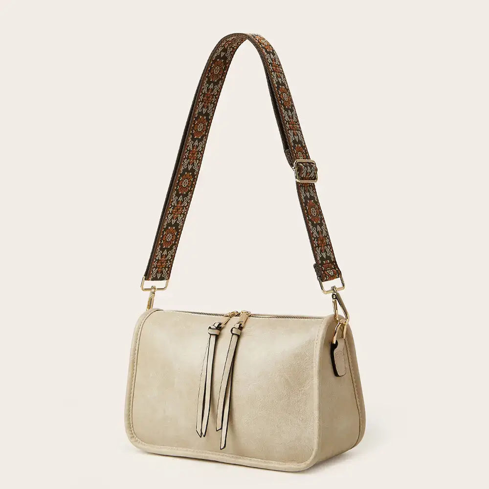 Beige faux leather crossbody bag with aztec embroidered bohemian wide strap in brown and green floral pattern
