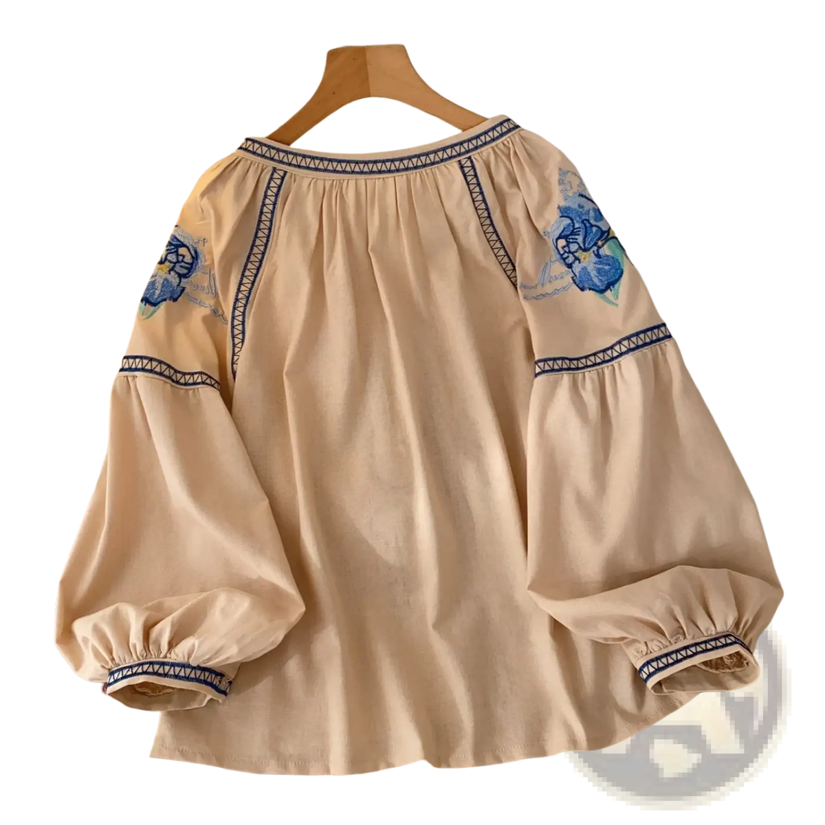 Beige boho embroidered cotton blouse with blue floral embroidery and geometric trim detail on long sleeves