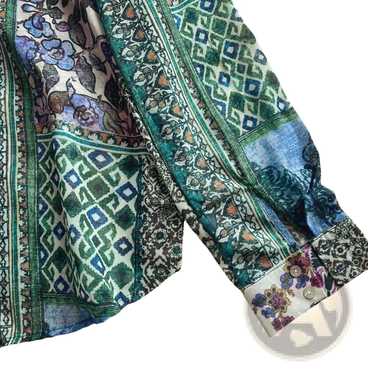 A vibrant long-sleeved boho floral patchwork chiffon blouse with green blue and purple patterns on lightweight fabric