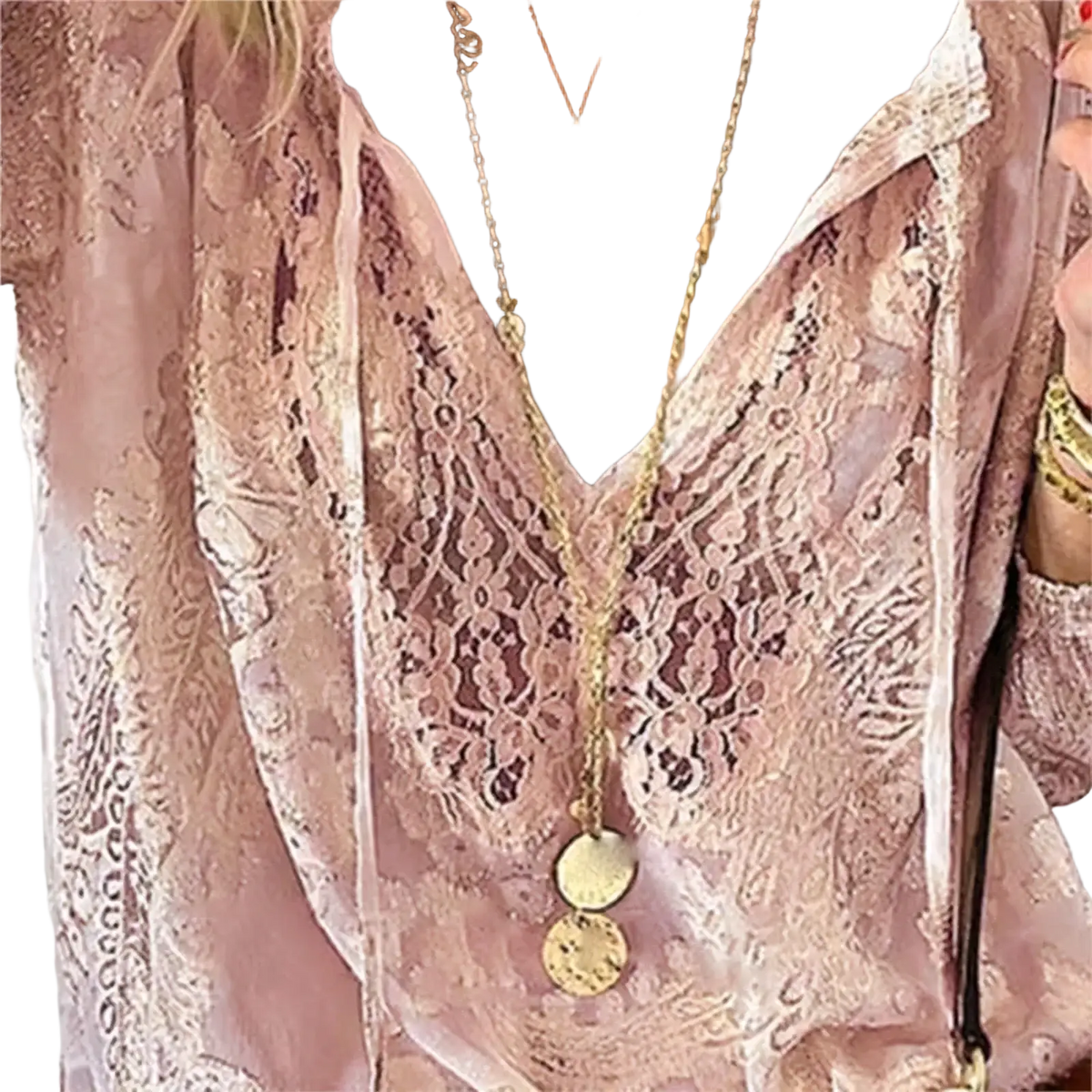 A delicate gold-toned necklace with stacked circular pendants worn over a sheer pink boho lace v-neck blouse