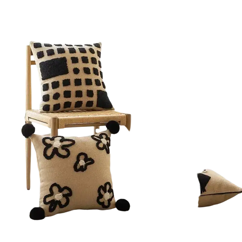 Beige boho throw pillow cover with black embroidered floral geometric patterns and pom-poms for living room decor