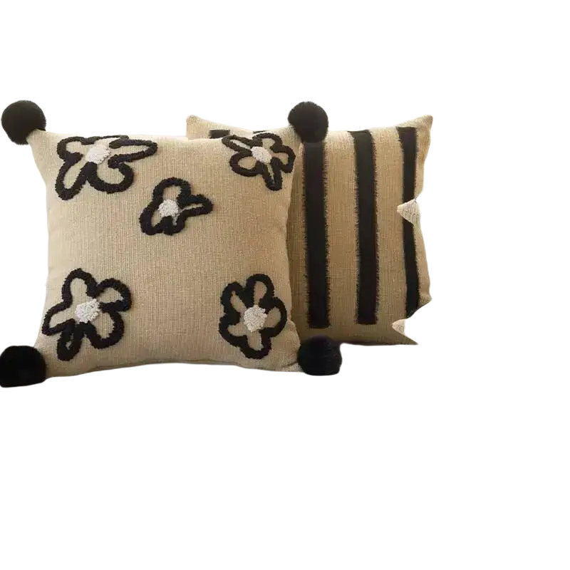 Beige boho throw pillow cover with black embroidered flowers white centers and pom-poms for living room decor