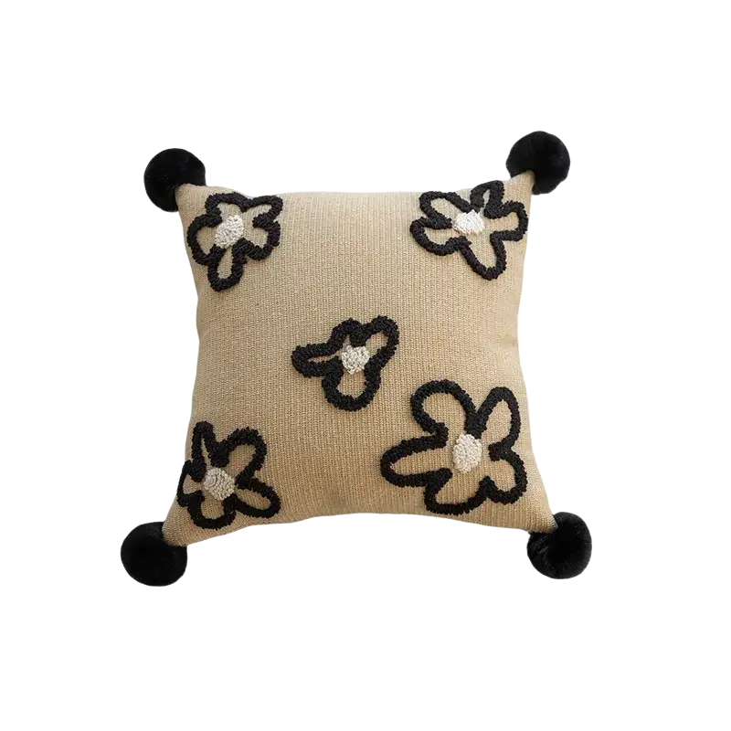 Beige boho throw pillow cover with black embroidered flowers and pom-poms for living room decor