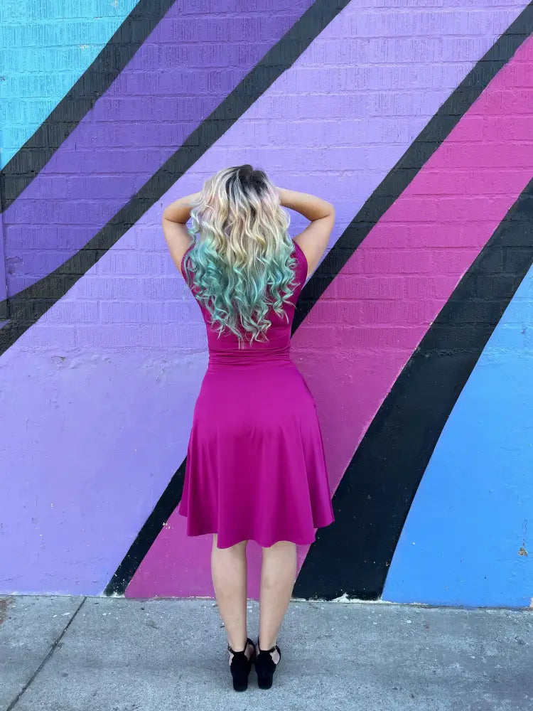 A vibrant magenta ruched a-line bombshell dress with fitted bodice pockets and a flared skirt