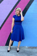 A royal blue retro ruched bombshell dress with collar short sleeves fitted mid-length and pockets in vibrant fabric