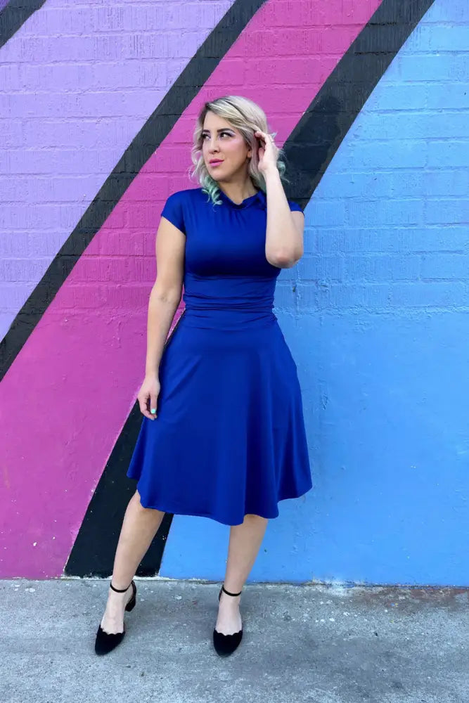 A royal blue retro ruched bombshell dress with collar short sleeves fitted mid-length and pockets in vibrant fabric