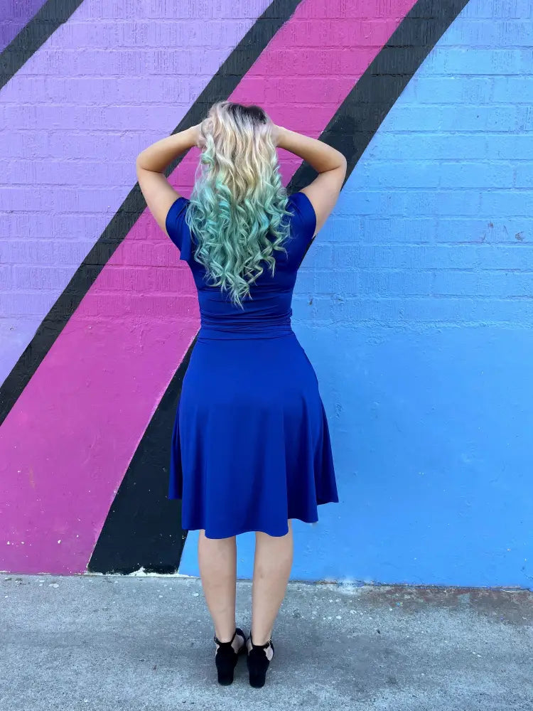 A vibrant royal blue retro ruched bombshell dress with short sleeves flared skirt and pockets