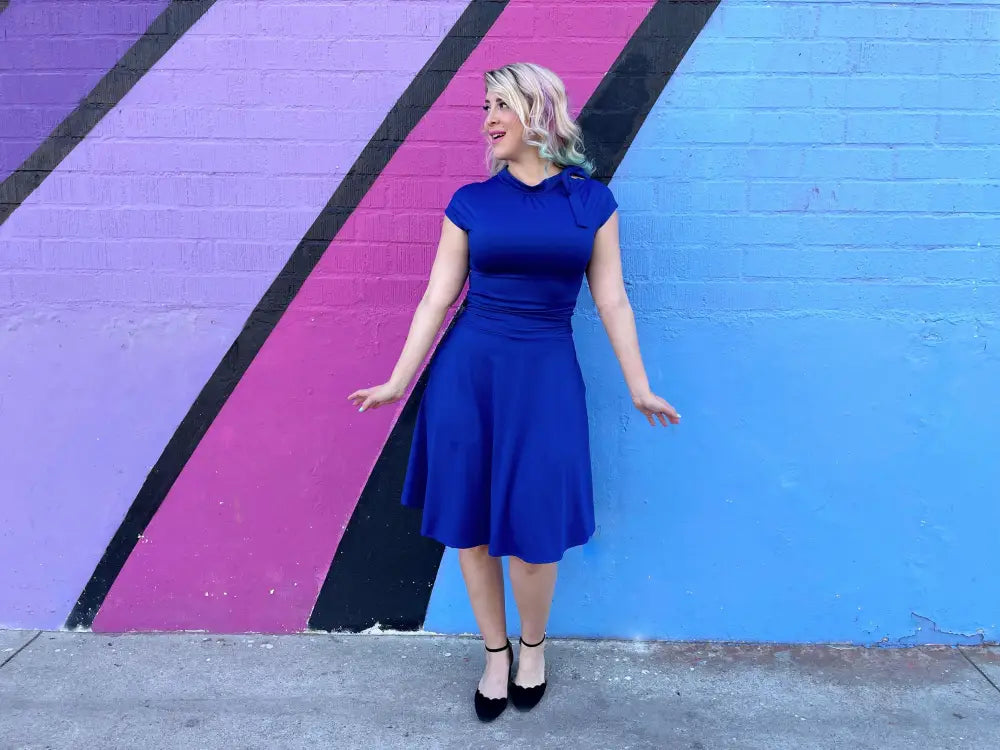 A vibrant royal blue retro fitted dress with short sleeves flared skirt ruched waistline and pockets