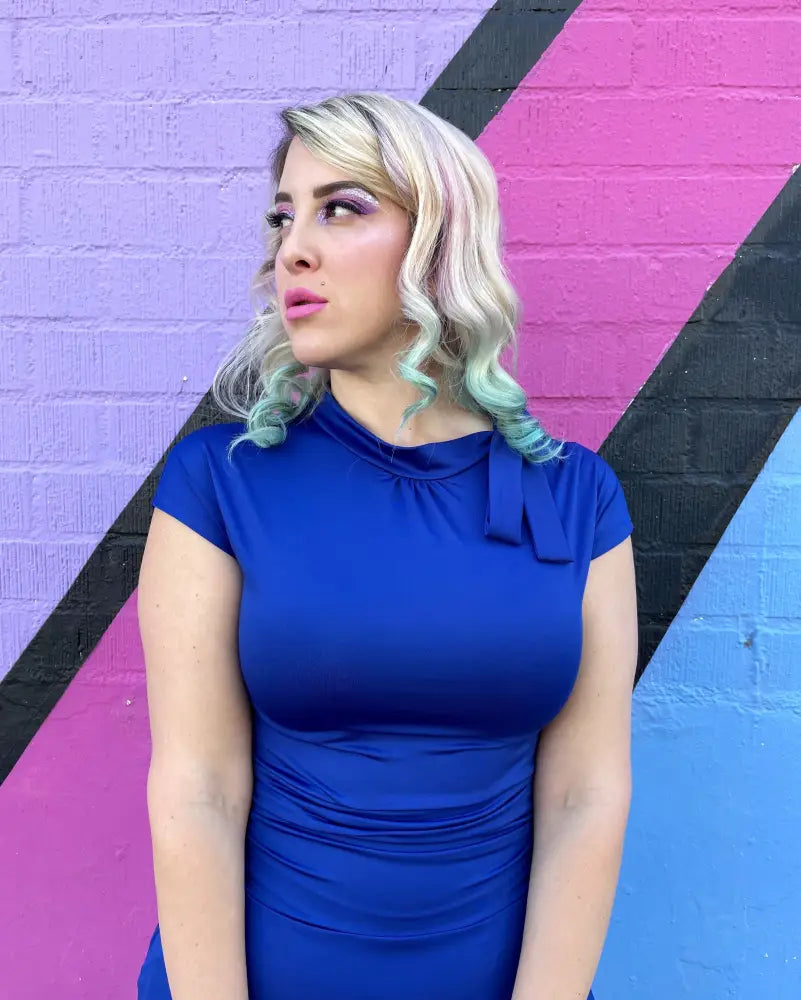 A vibrant royal blue retro ruched bombshell dress with a high neckline short sleeves and pockets