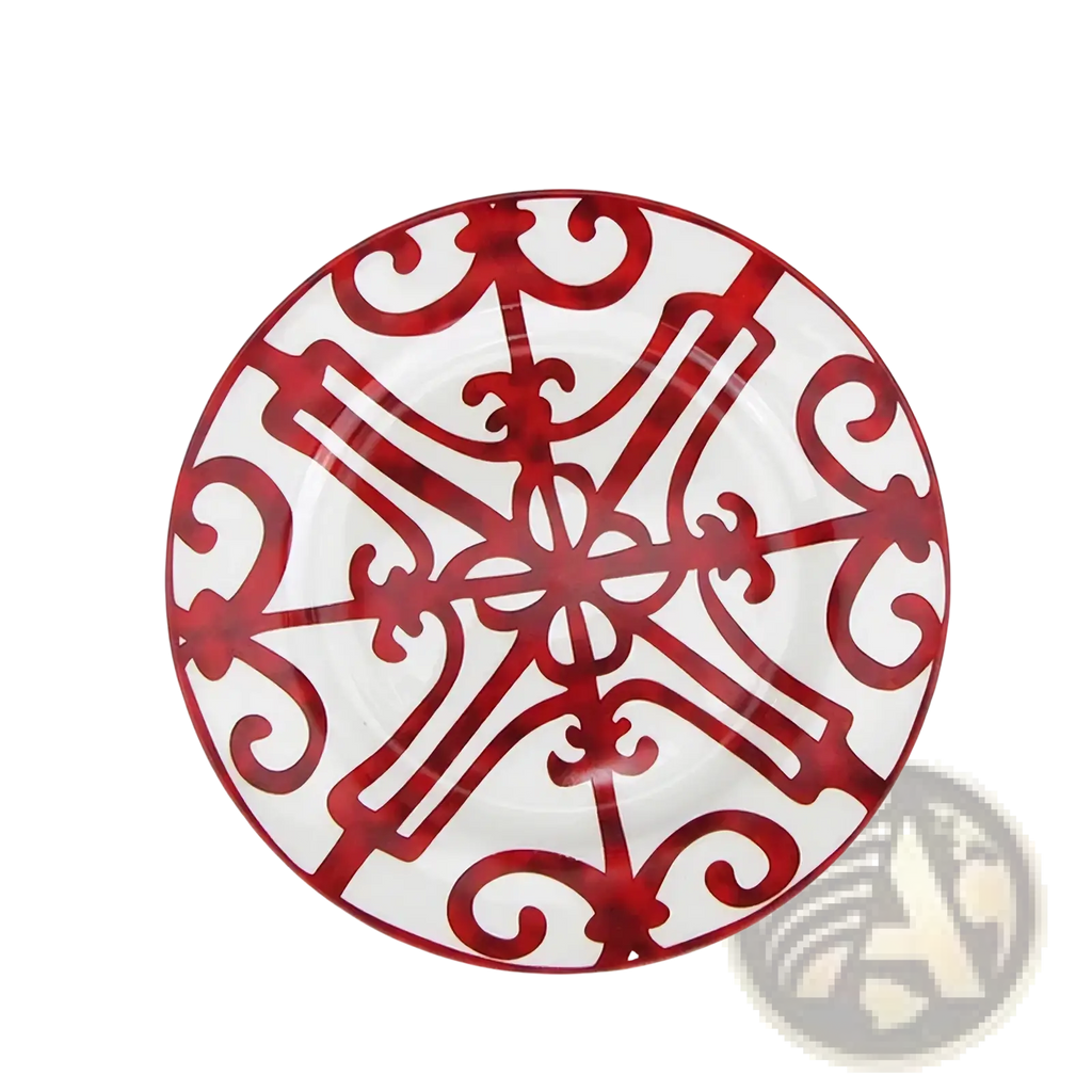 A white bone china plate with bold red ornate scroll and cross-like patterns from the red scroll dinnerware set