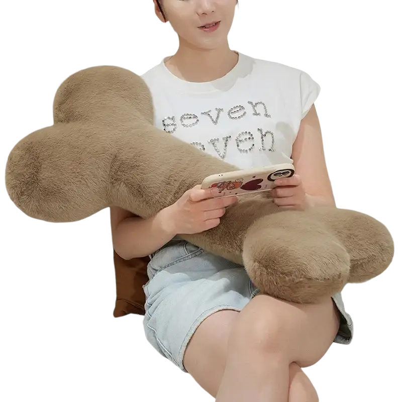 A tan kawaii bone shape plush pillow with soft fuzzy texture designed as a comfortable nap cushion