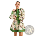 A woman wearing a cream botanical print puff sleeve midi dress with green collar cuffs and a flared skirt