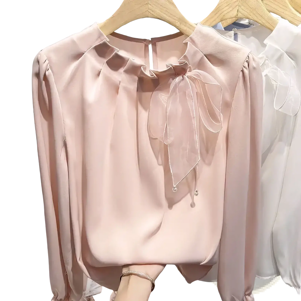 A soft blush pink satin bow chiffon blouse with long sleeves and a delicate sheer bow neckline for elegant office wear