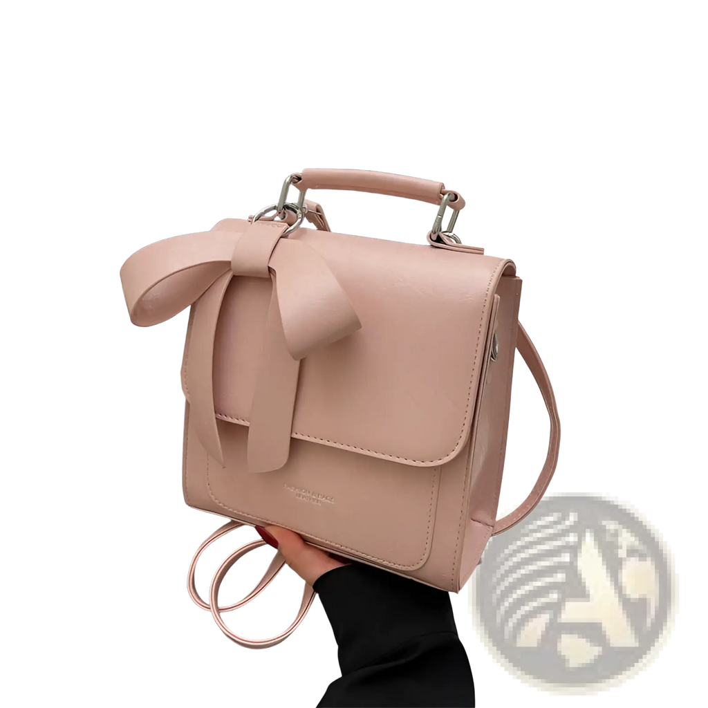 A soft pink faux leather bow crossbody bag with silver-toned hardware perfect for fashion handbag use