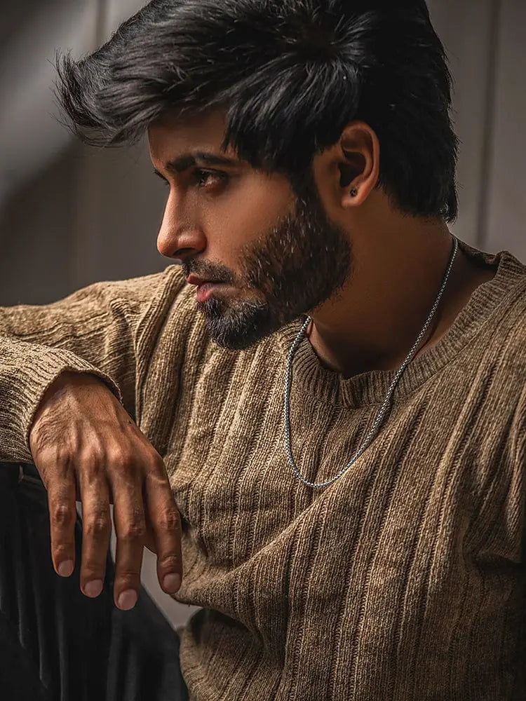 A man wearing a textured earth-toned knit sweater with a 2.5mm silver box chain 316l stainless steel necklace