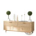 Light oak wooden sideboard with six drawers and tapered legs beside a set of two boxwood topiary balls in white pots