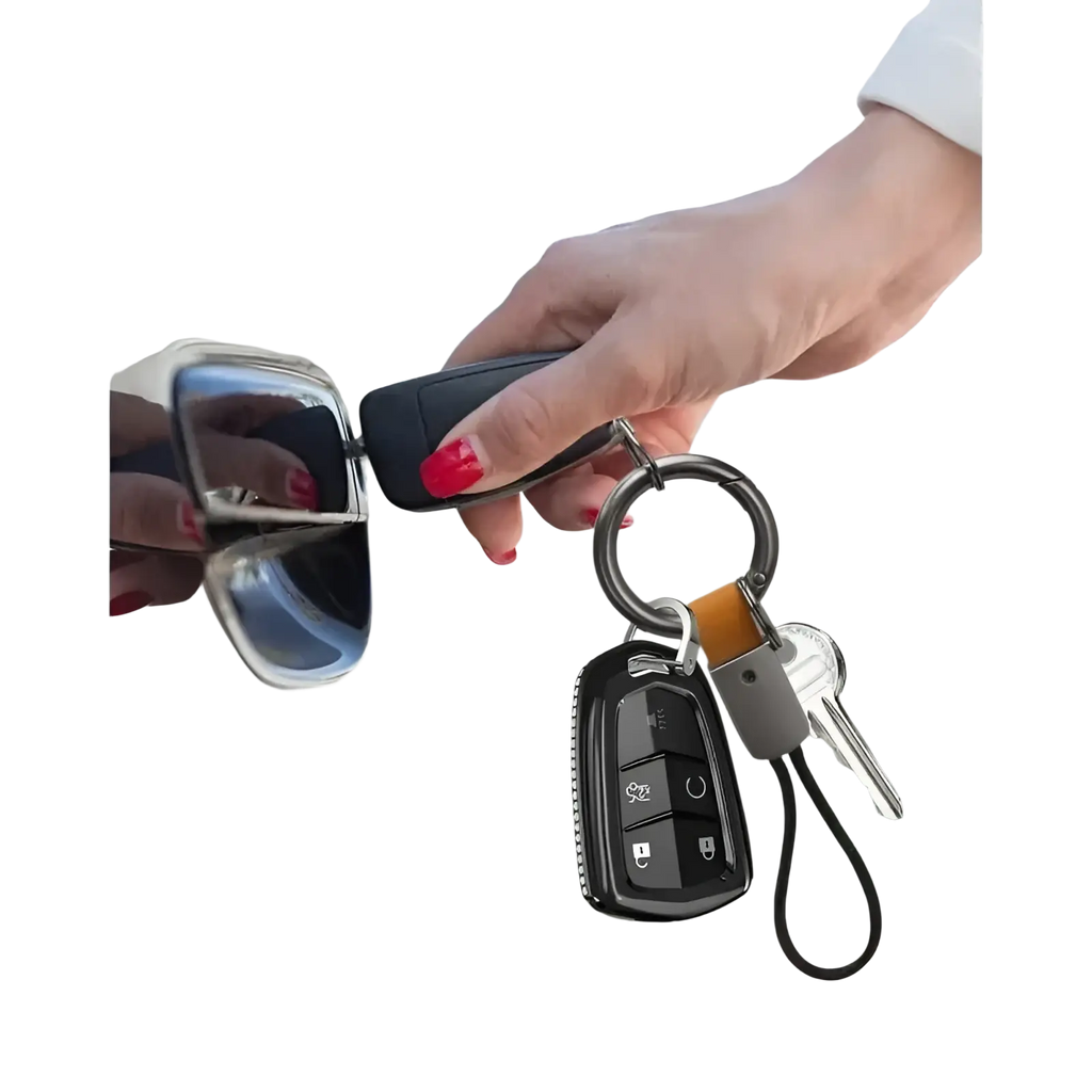 Black key fob with silver buttons and textured surface attached to braided leather car keychain universal holder
