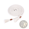 Cream-colored braided rope belt with tassels and brown leather ends coiled on magazine page for women waistband accessory