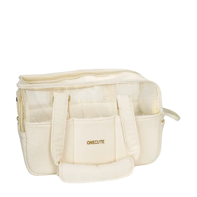 Cream-colored breathable canvas small dog pet backpack with mesh side panels and front pocket featuring gold brand lettering