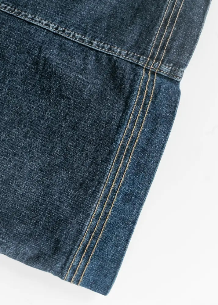 Bria dark wash denim maxi skirt with side slit showing dark blue fabric and contrasting light stitching along seam