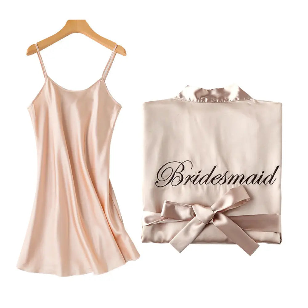 A delicate blush pink embroidered satin bridal nightgown and robe set with bridesmaid script and matching bow