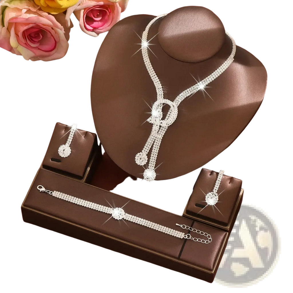 A sparkling silver bridal diamond jewelry set with cascading clear crystals and decorative knots on a brown bust