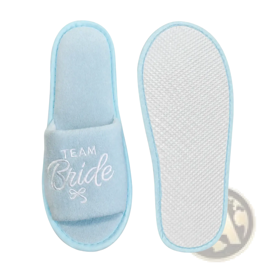 Light blue slip-on bridal party slippers embroidered with team bride in white script and a small bow design