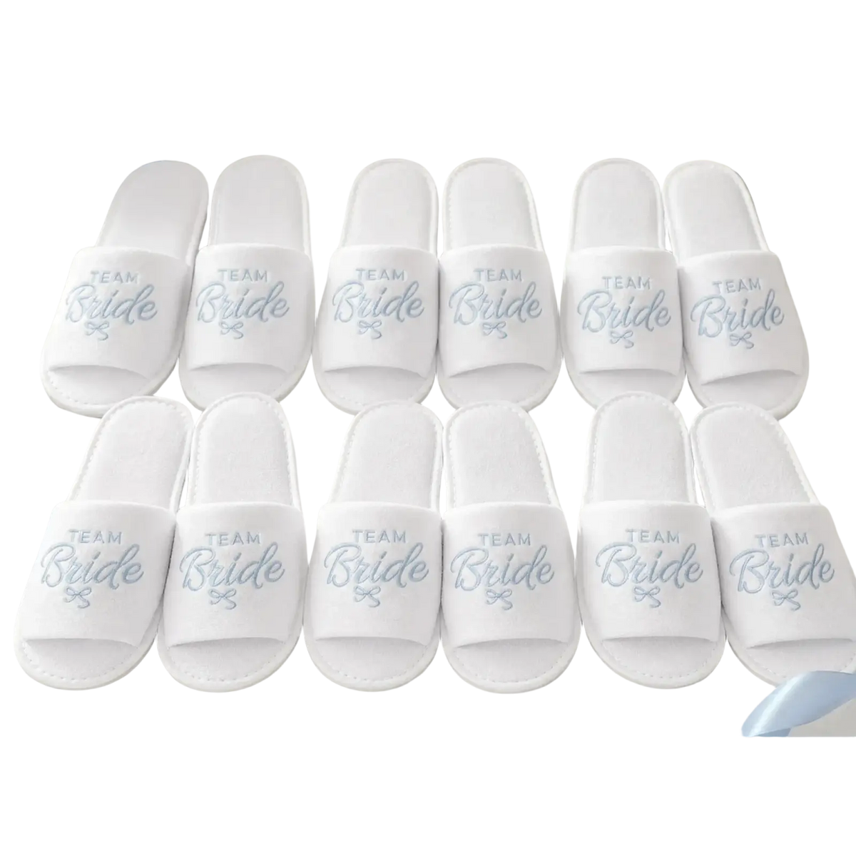 White team bride slip-on slippers with silver embroidered text and bow design in a bridal party gift set