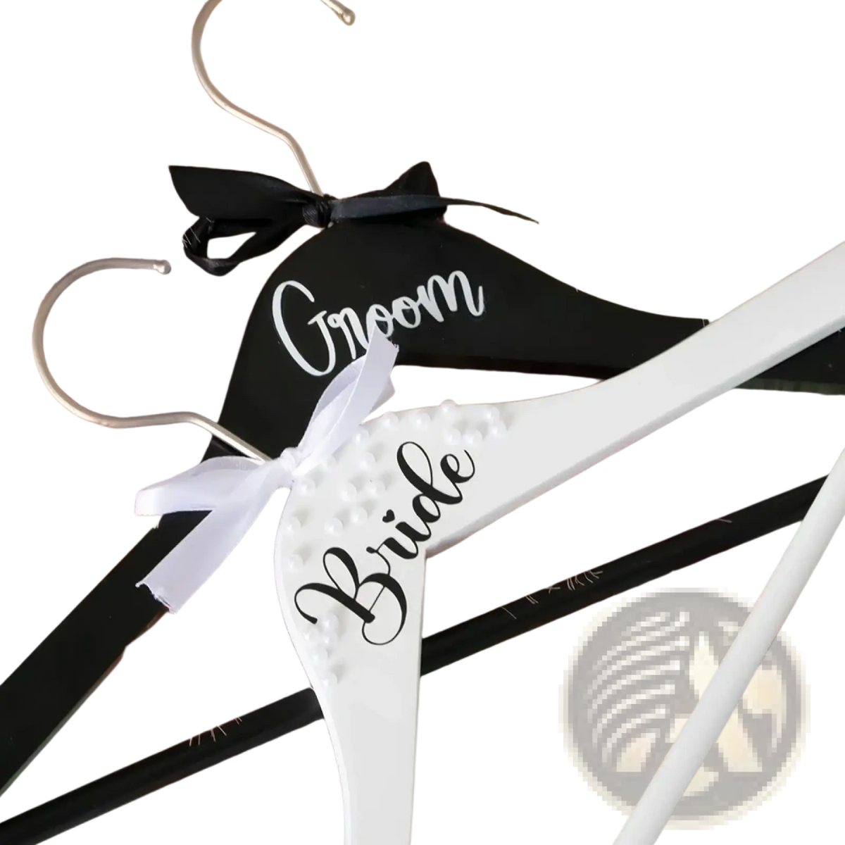Black and white wooden bride and groom pearl wedding hangers set with labeled bows for bridal attire display