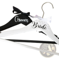 White and black personalized wooden bride and groom wedding hangers with pearl embellishments and ribbon bow