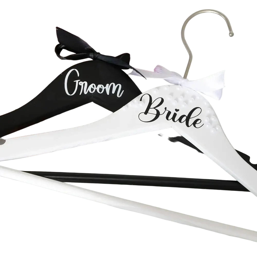 White and black personalized wooden bride and groom wedding hangers with pearl embellishments and ribbon bow