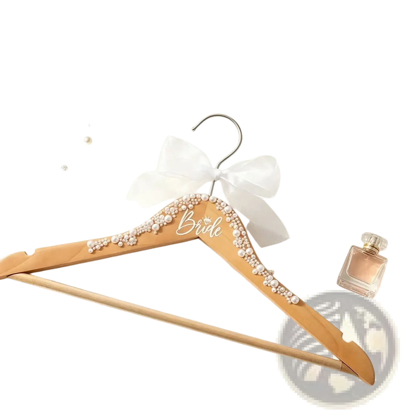 A light wood bride bridal hanger adorned with pearls and a delicate white bow from a wedding hanger set