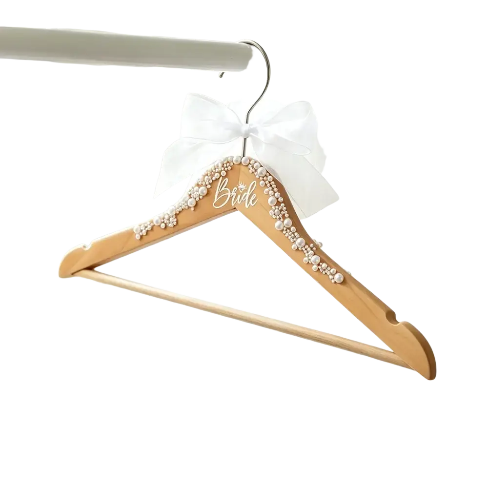 A light wood bride wedding dress hanger adorned with pearls and elegant script from the bride and groom set