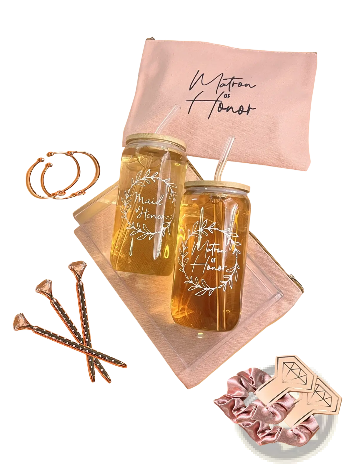 Two clear glass mason jar tumblers with gold lids and white maid of honor wreath designs filled with golden liquid