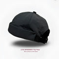 Black brimless hat quick drying adjustable cap with folded brim and strap shown from the back side